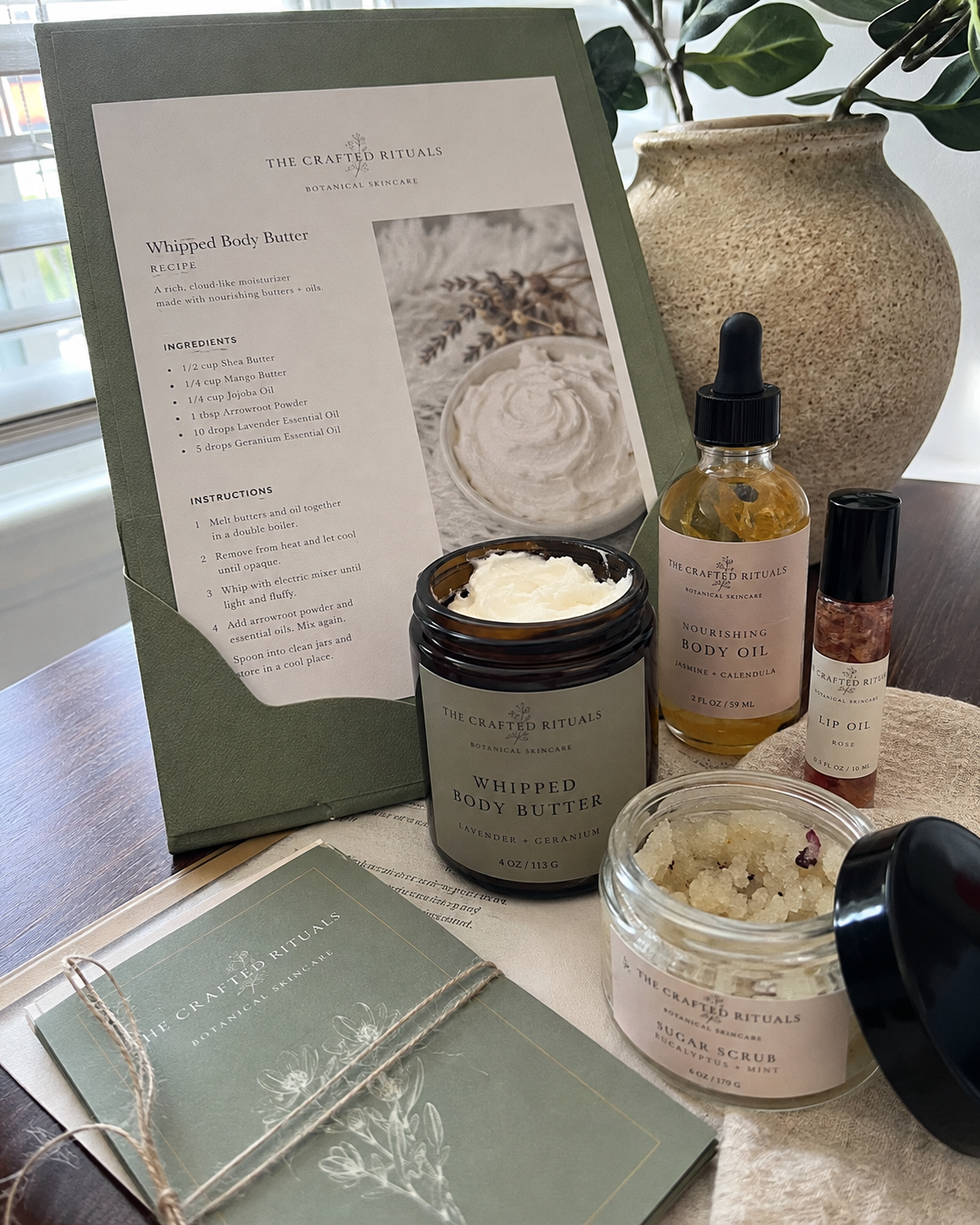 Printed The Crafted Rituals recipe page beside whipped body butter, body oil and lip oil
